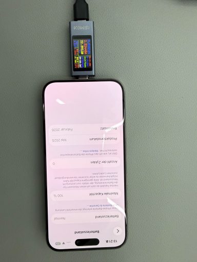 Ein Smartphone mit einem angeschlossenen USB-Gerät auf einem grauen Tisch.